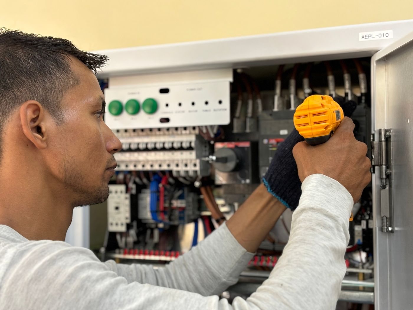 Electrician working inside an open residential electrical panel