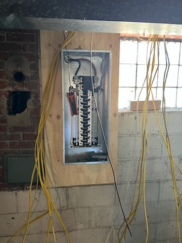 A new load centre set into a basement wall during a residential service upgrade