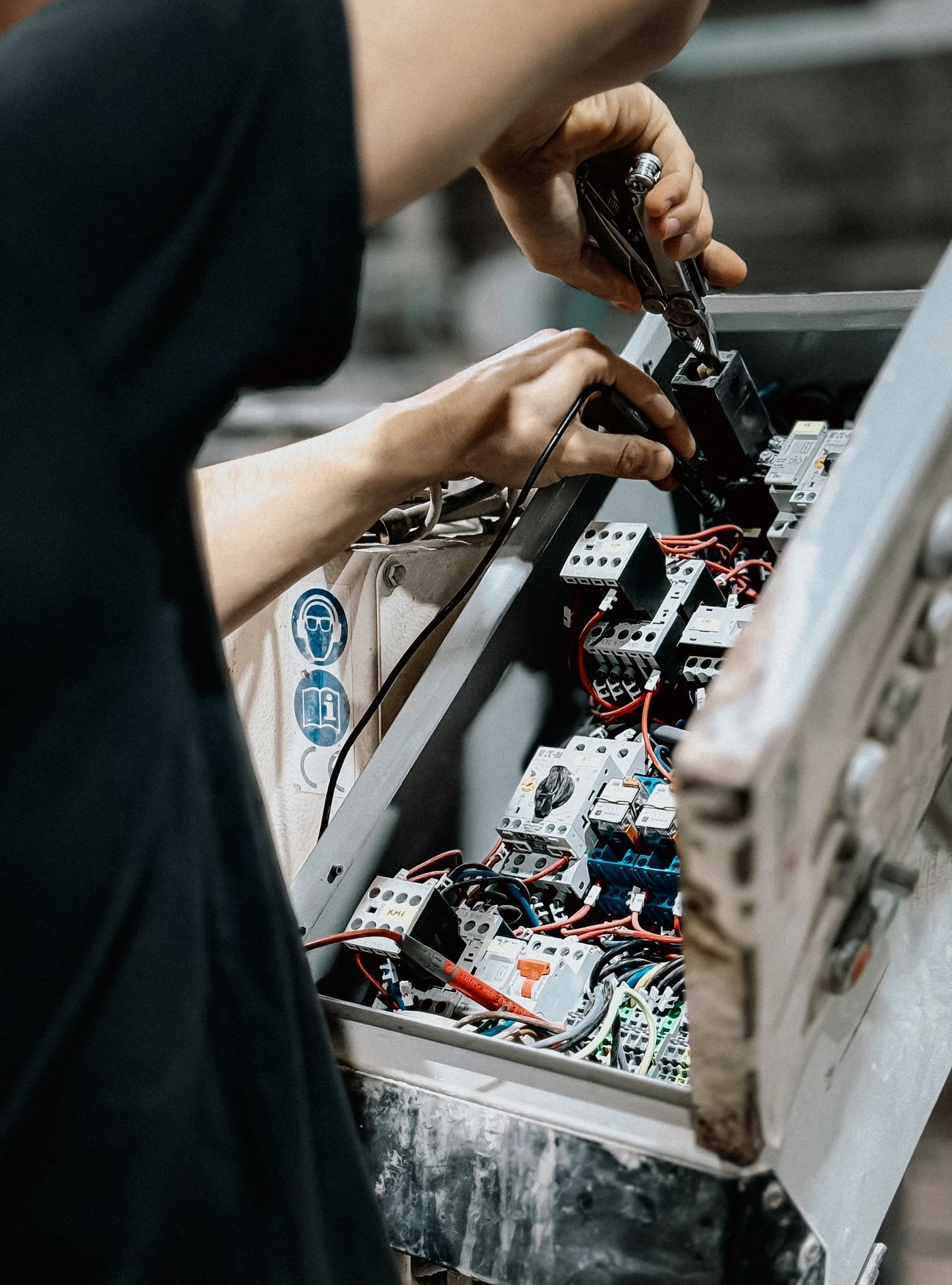 Technician wiring a small commercial electrical control panel