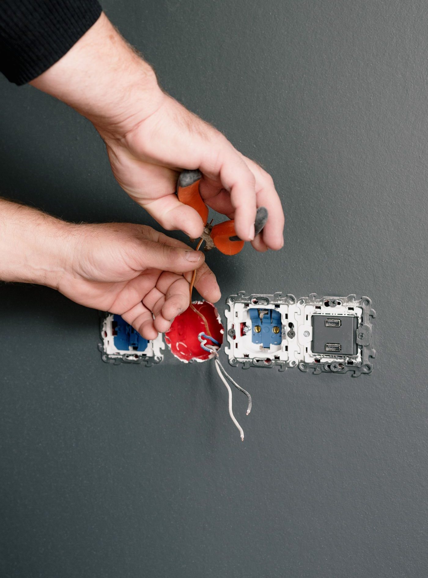 Electrician installing a wall switch and receptacle during a renovation